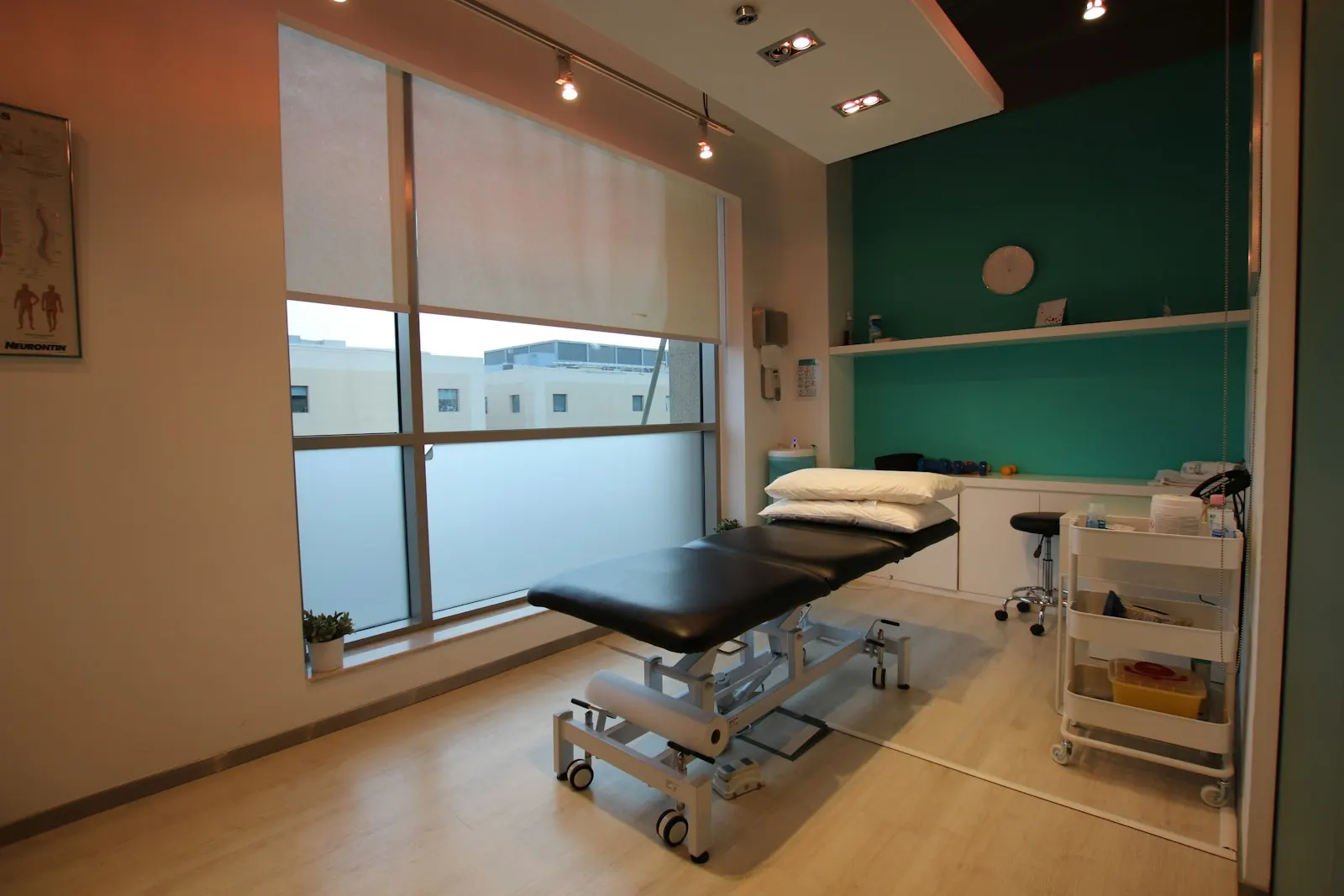 Sala de tratamiento de fisioterapia con camilla y ventanal