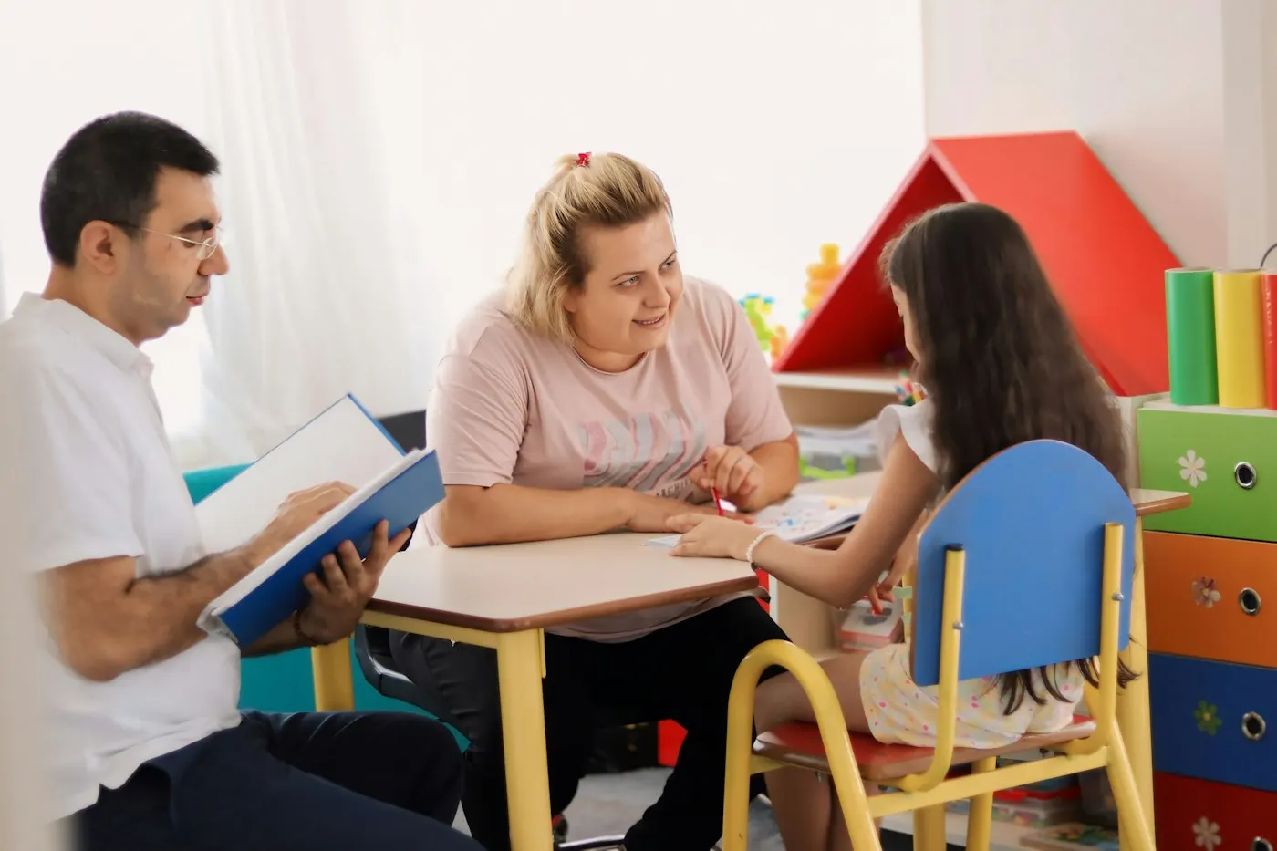 Logopeda con una niña y sus padres en la consulta